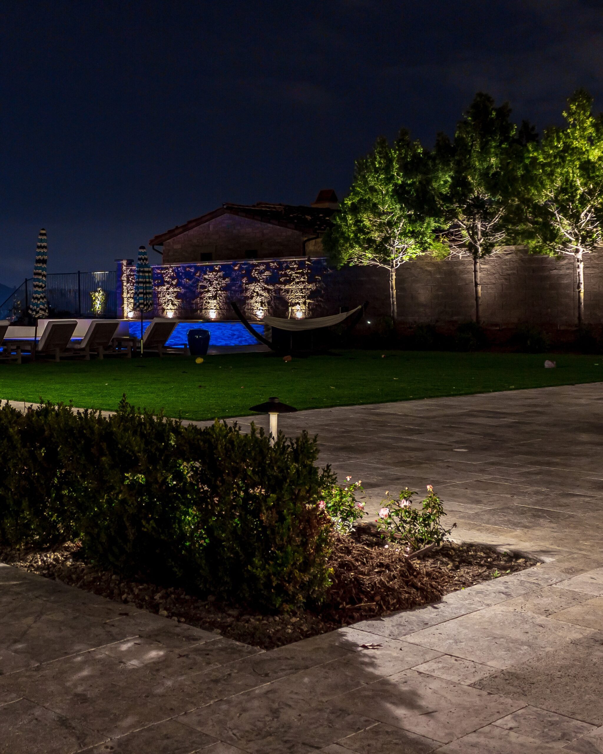 Backyard entertaining space lit with outdoor lighting